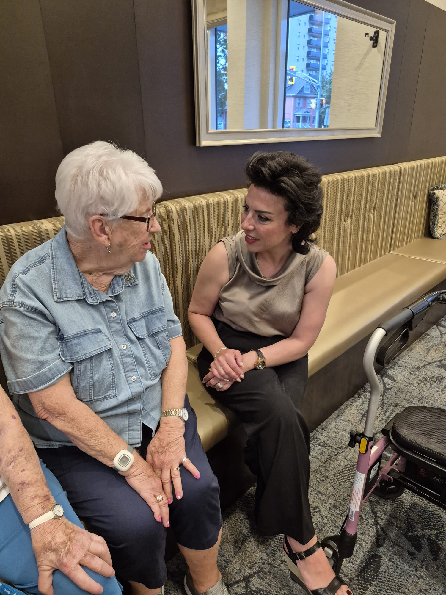 Bahareh Barahmand sitting and talking with a senior resident at a community centre